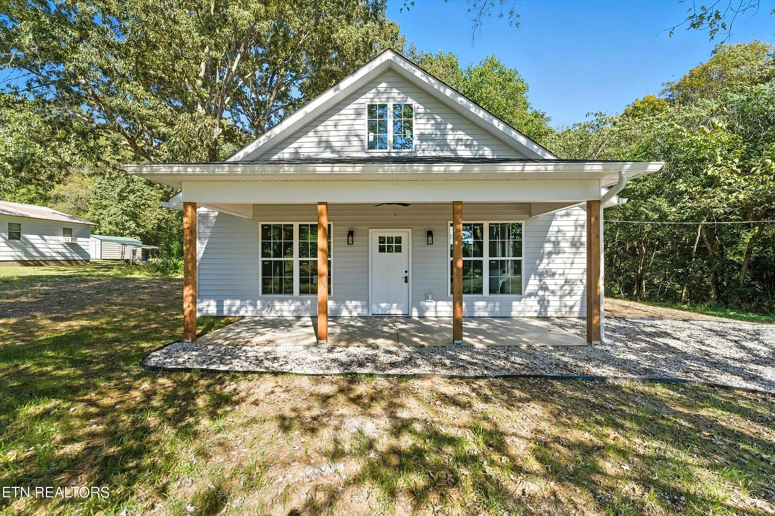 Custom-built white craftsman cottage with cedar porch columns and covered entry in Knoxville, TN