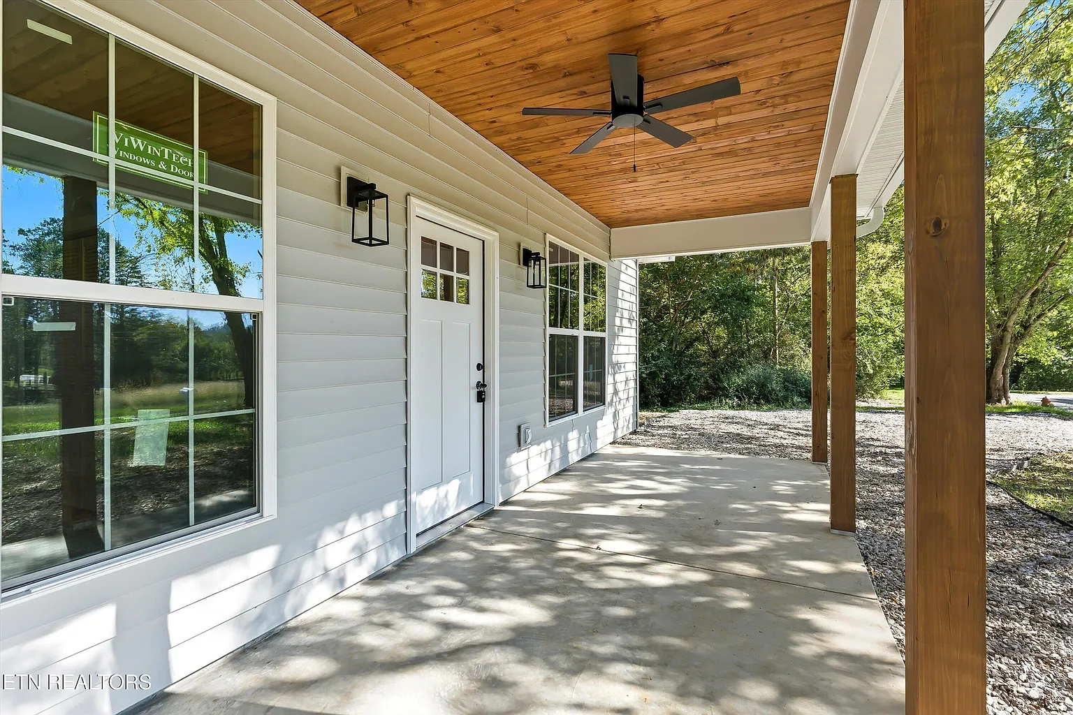 Covered front porch with natural wood ceiling and cedar columns on a Recursive Construction custom home in Knoxville, Tennessee