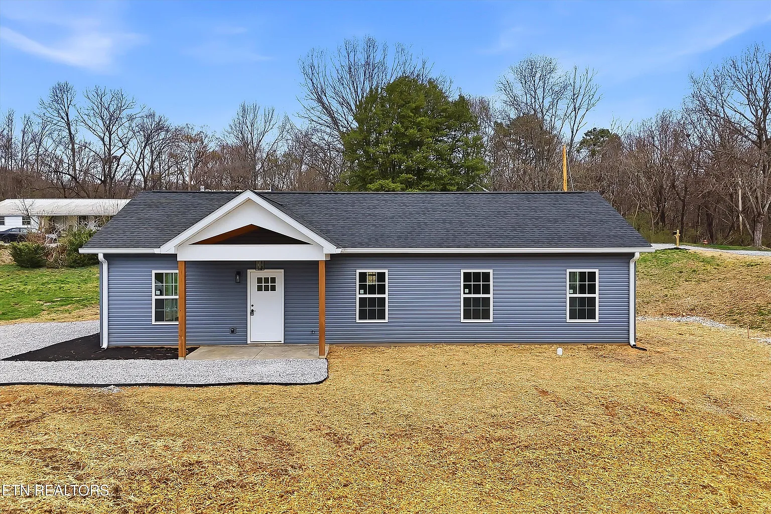 New construction blue vinyl-sided ranch home with covered entry porch built by Recursive Construction